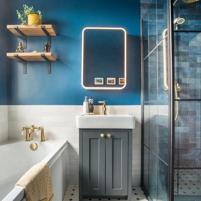 Blue and white bathroom with a backlit mirror