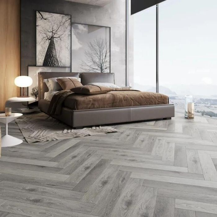 Bedroom with grey herringbone flooring and large windows