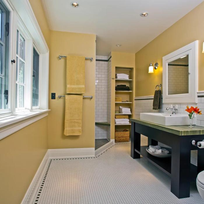 Yellow walls with white tiles and dark vanity in the bathroom