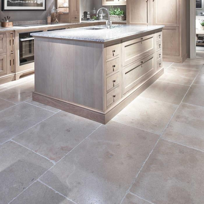 Light wood cabinets and limestone tiles in kitchen