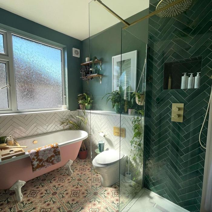 Green and white bathroom with pink tub and patterned floor tiles