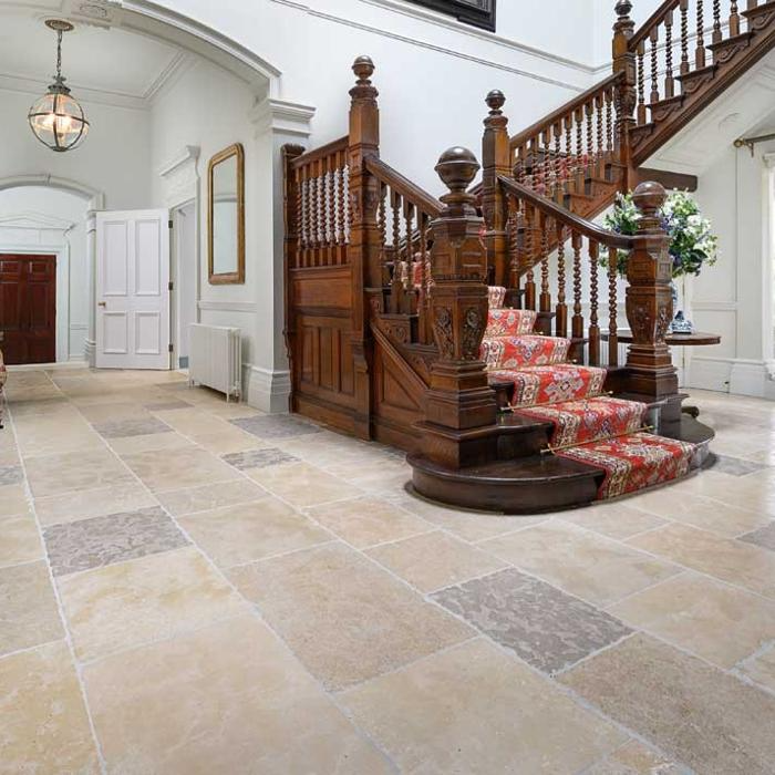 Grand hallway featuring an ornate staircase and limestone floor tiles