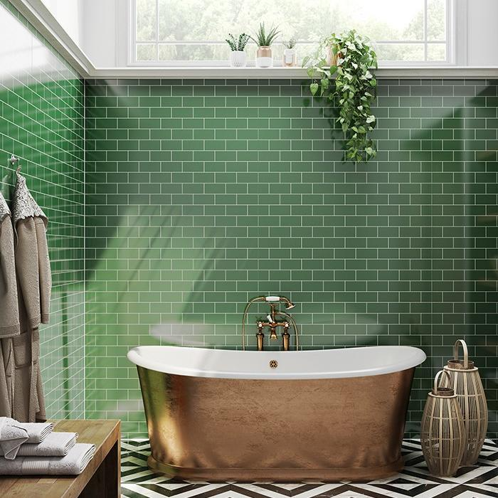 Bathroom with green tiles and a gold freestanding tub