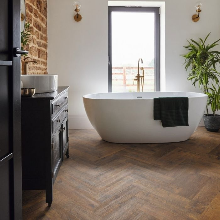 Bathroom with dark herringbone flooring and freestanding tub