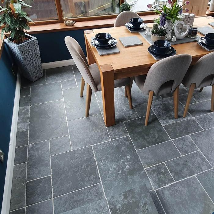 Wooden dining set on top of grey limestone floor tiles