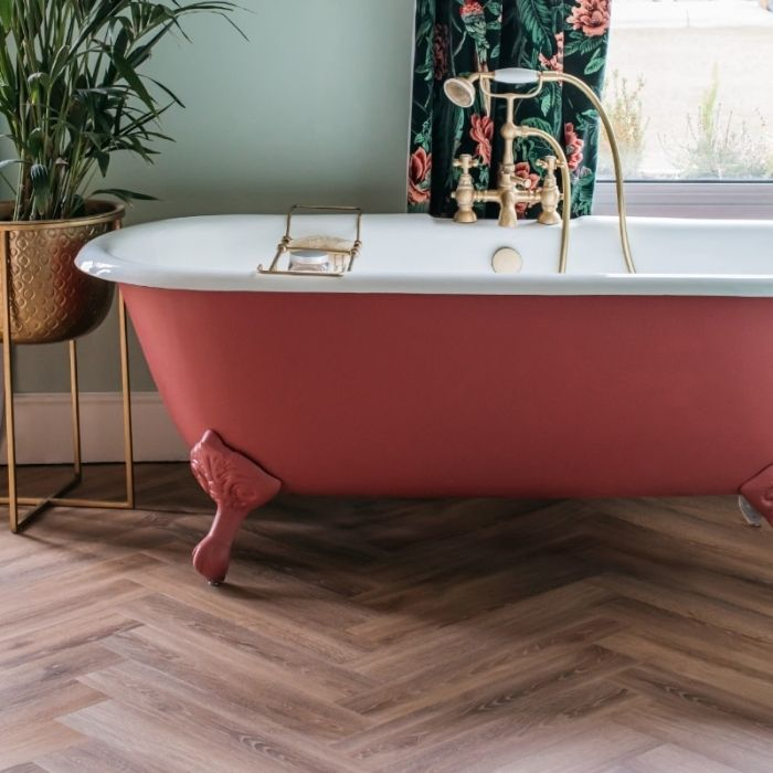 Bathroom with red clawfoot tub and herringbone flooring