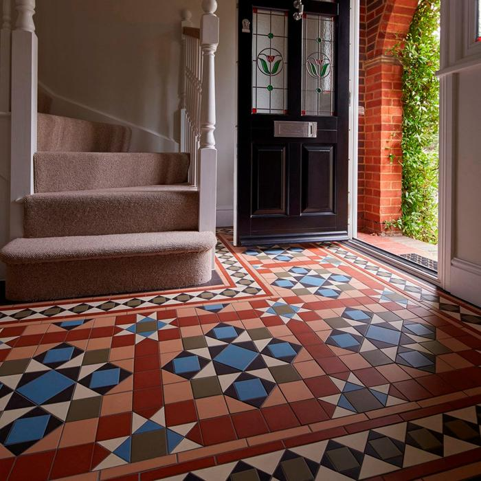 Colourful patterned tiles beneath the stairs in traditional foyer