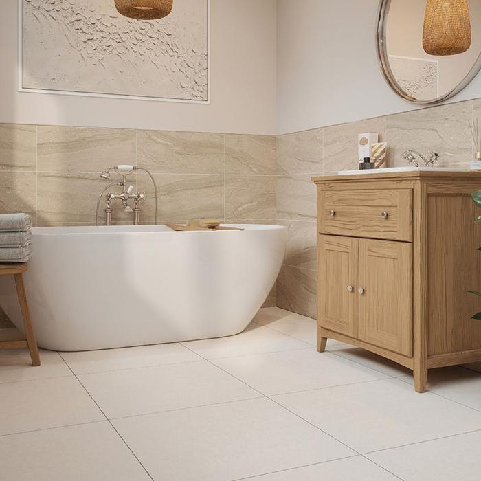 Freestanding bathtub with light stone tiles and wooden vanity