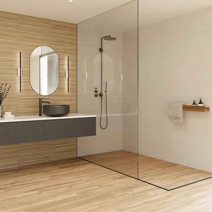 Modern bathroom with light wood-themed flooring and glass shower