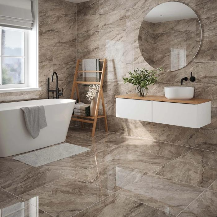 Marble effect tiles throughout bathroom with freestanding tub