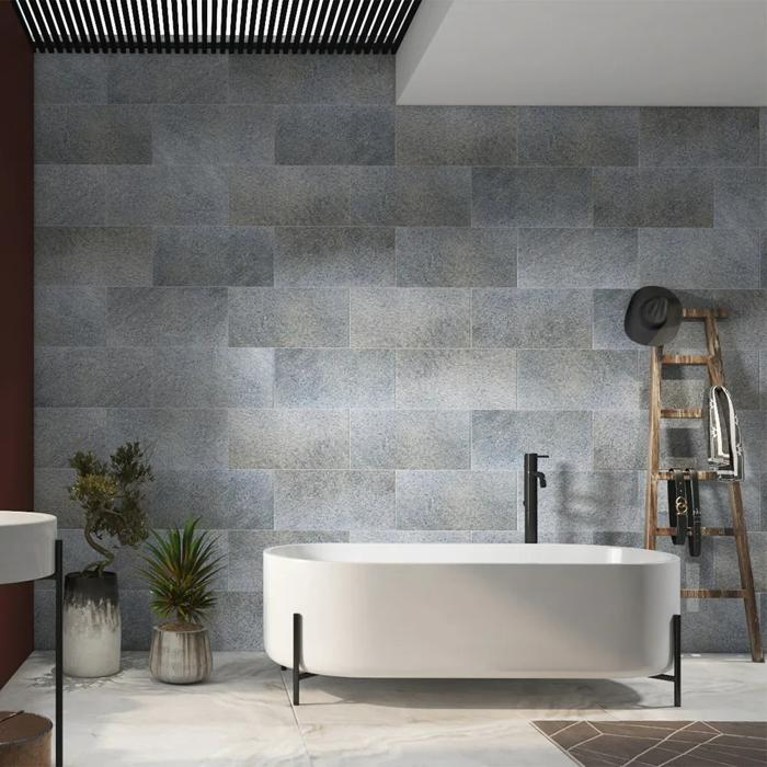 Freestanding bathtub against textured grey wall in modern bathroom