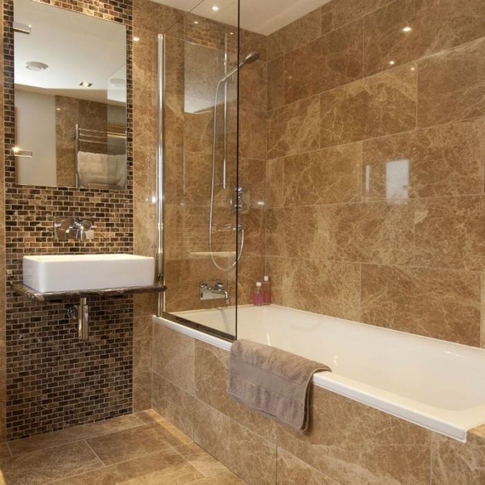 Brown marble tiles with mosaic accent wall in a bathroom