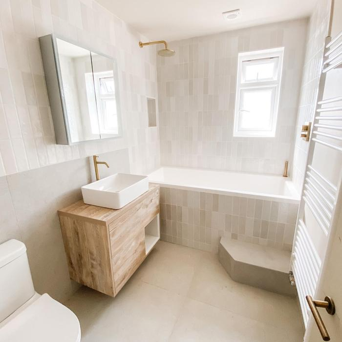 Bright, minimalist bathroom with wood vanity and white tiles