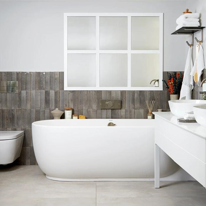 Freestanding bathtub with textured grey wall tiles