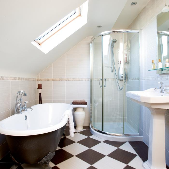 Attic bathroom with clawfoot tub and checkered floor tiles