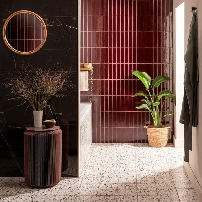 Glossy dark red tiles with gold accents in the bathroom