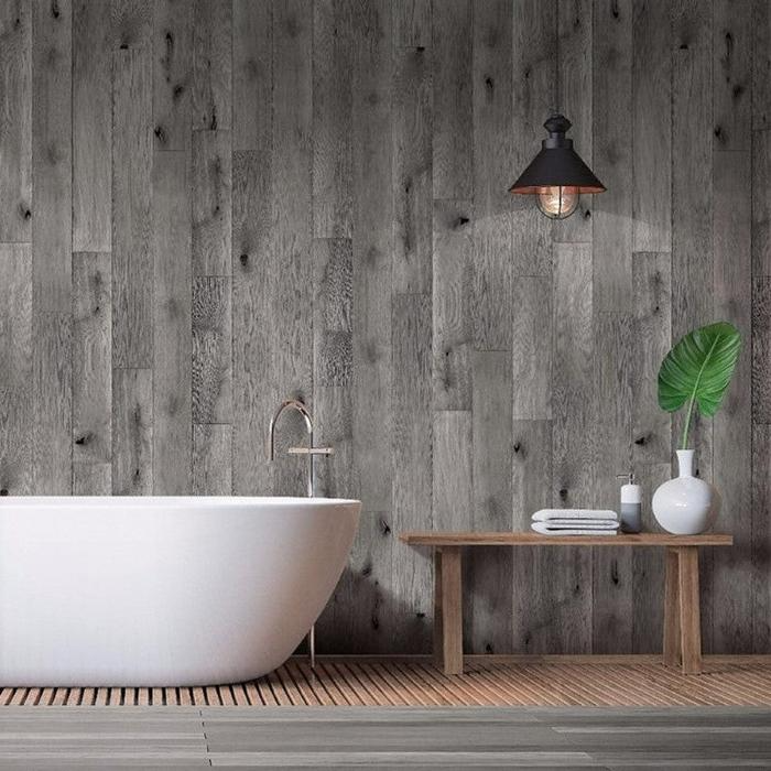 Grey wood wall panels in a bathroom with a white tub