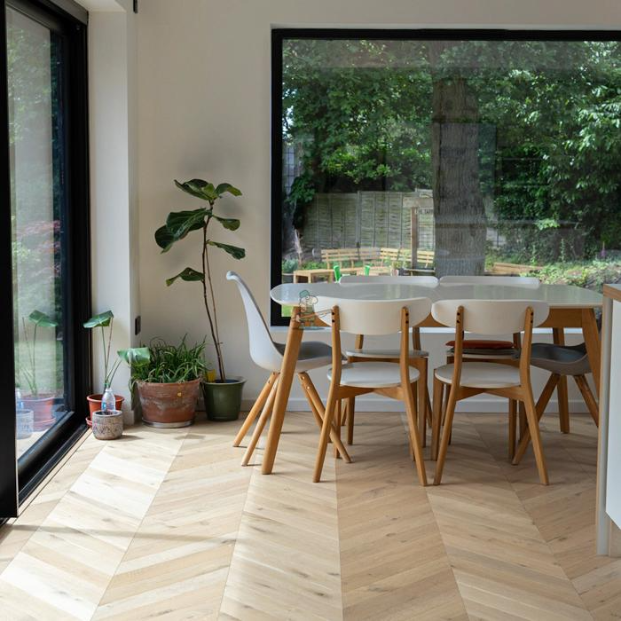 Modern dining area with light chevron flooring