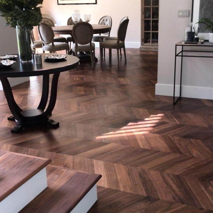 Elegant hallway and dining area with dark chevron flooring