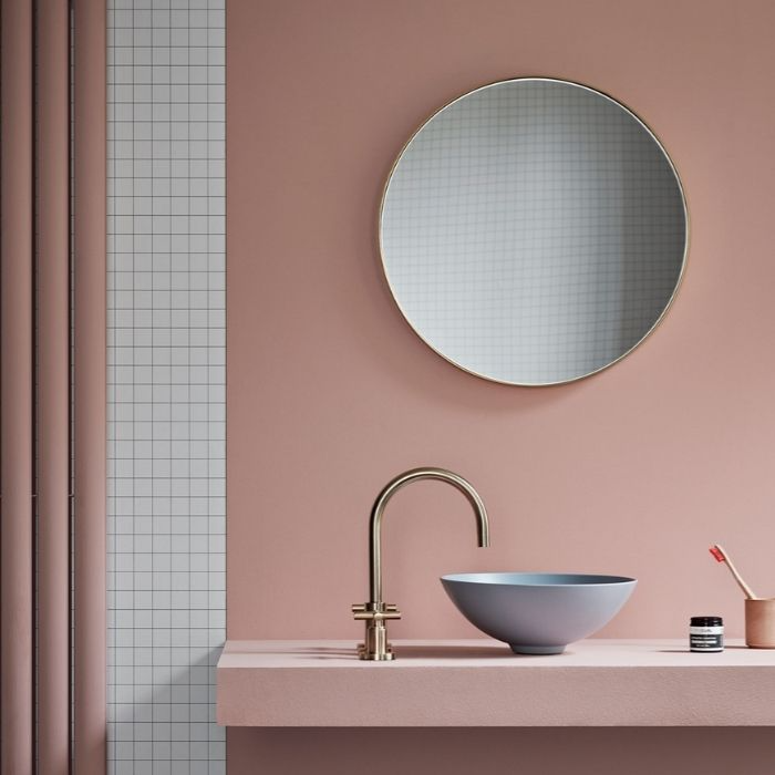 Pink painted walls with small white grid tiles in bathroom