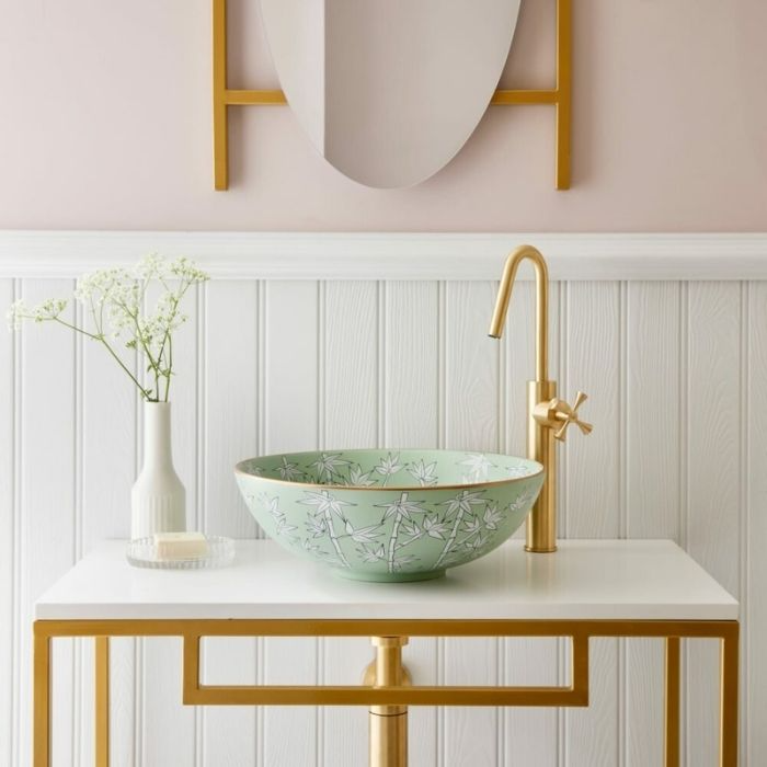 Floral-patterned sink with gold tap and pastel pink walls