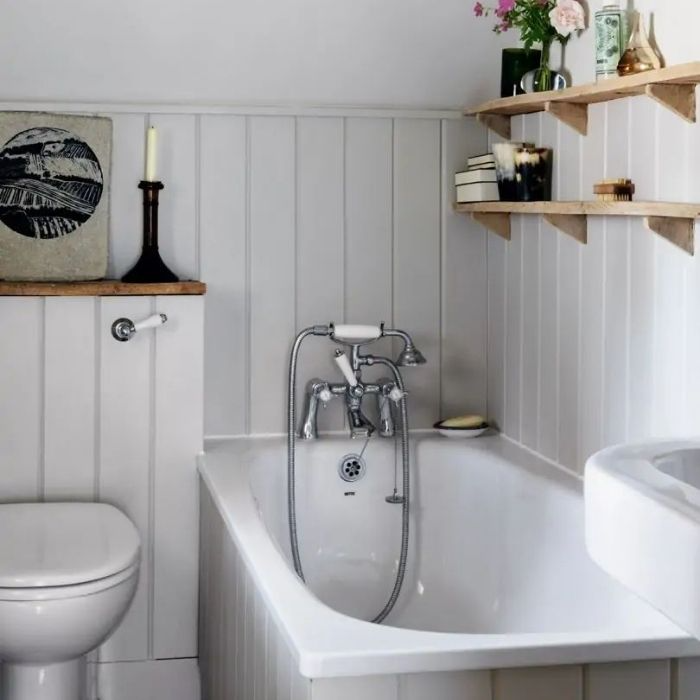 White-panelled country bathroom with rustic wooden shelves