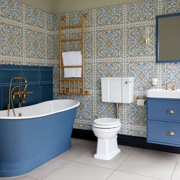 Ornate Victorian wall tiles with blue clawfoot bath