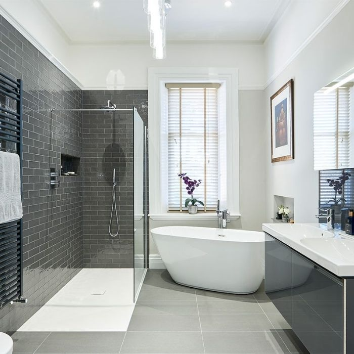 Glossy grey tiles with a freestanding bath in family bathroom