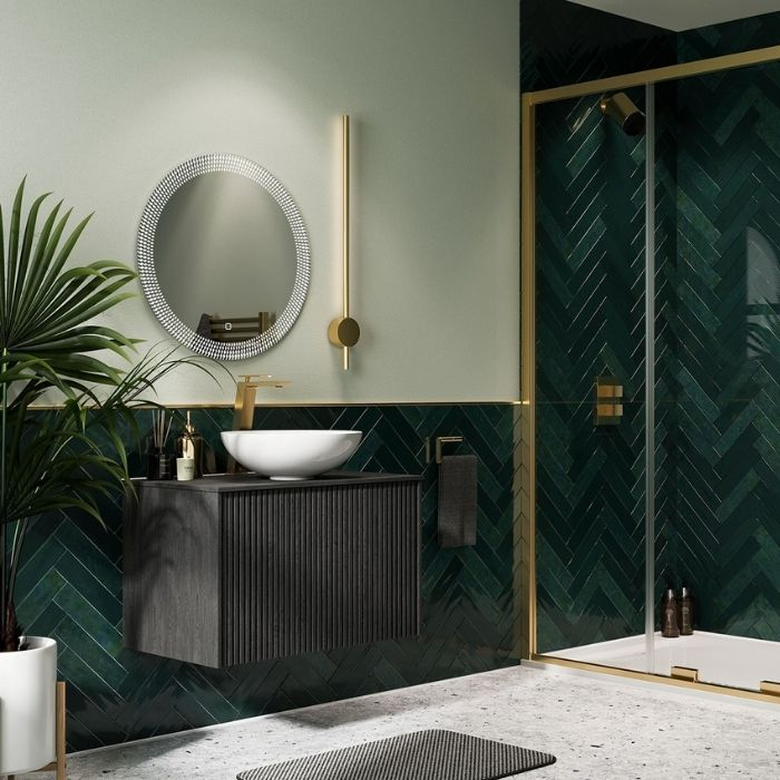 Modern bathroom with dark green herringbone tiles and white sink