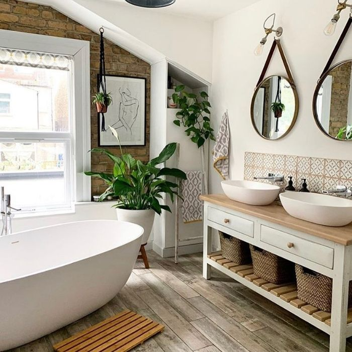 Freestanding tub with wooden accents and plants in bathroom