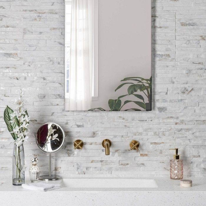 Stacked stone effect tiles behind a modern sink