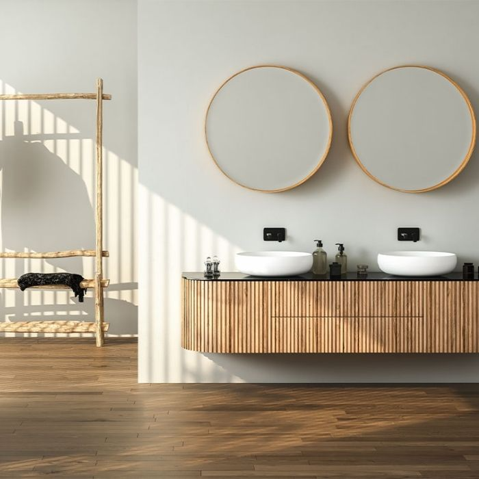 Wooden floating vanity with round mirrors and natural light