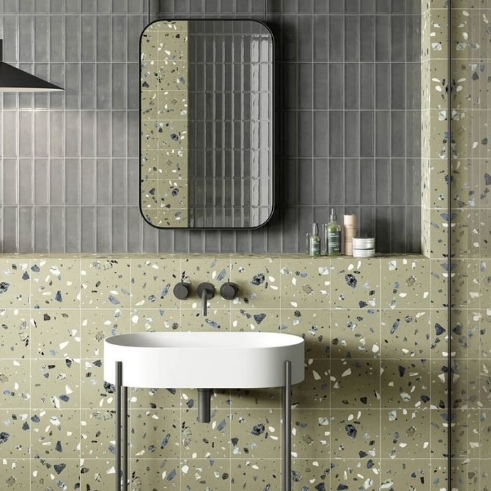 White sink with terrazzo tiles and dark grey wall tiles