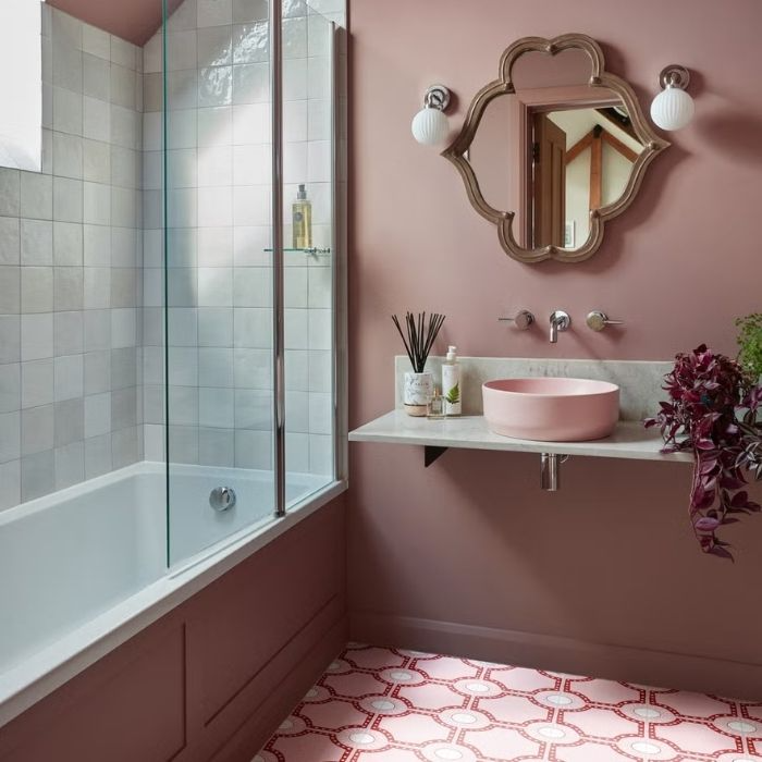 Pink sink and patterned floor tiles in a charming bathroom