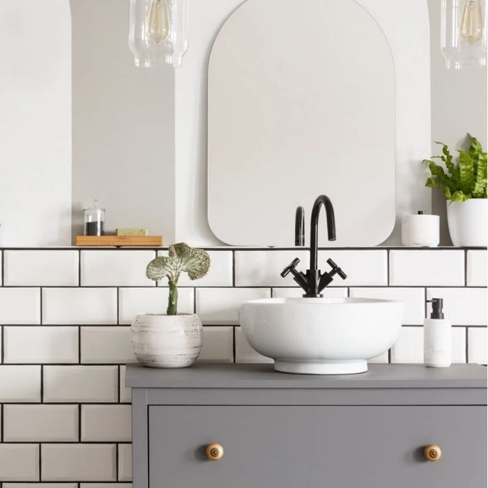 Mirror and white sink with black tap on grey vanity