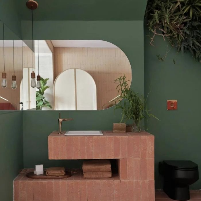 Rustic bathroom with terracotta vanity and green walls