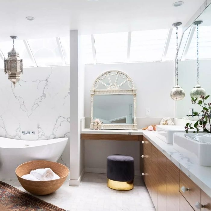 White marble tiles with wooden accents in a bright bathroom