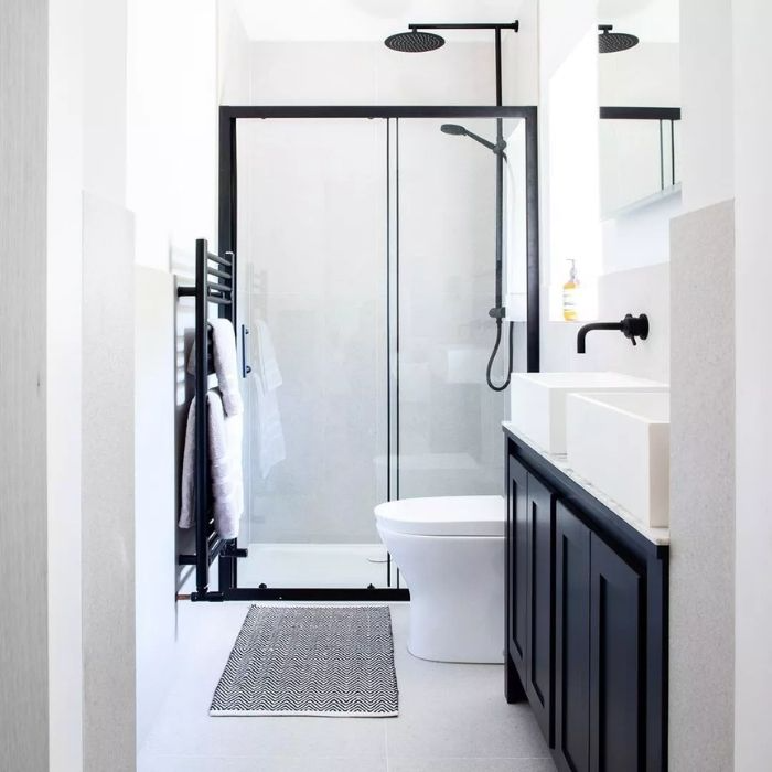 Black and white bathroom with sleek fixtures and glass shower