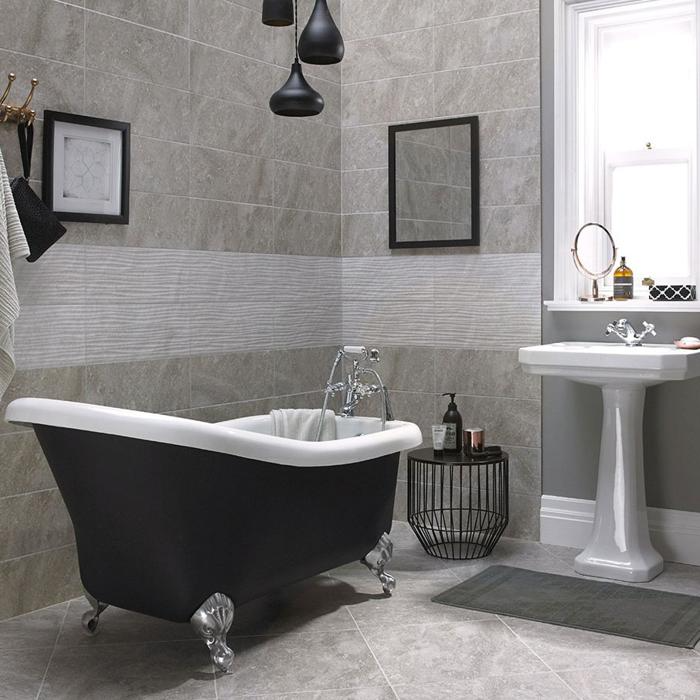 Pedestal sink and clawfoot tub in stone-tiled bathroom