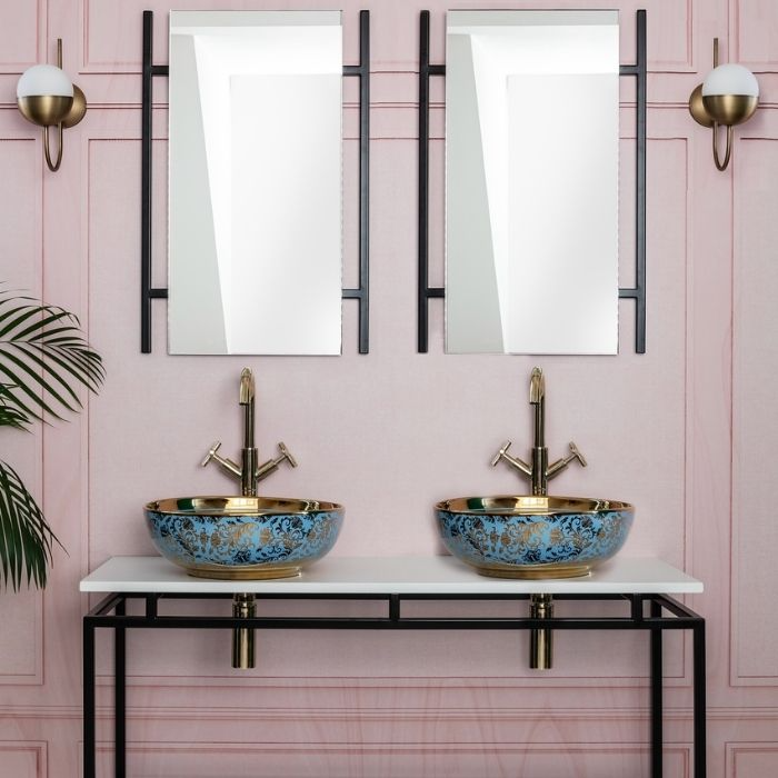 Double sinks with ornate blue basins and pink wall panels