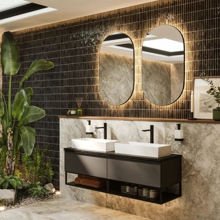 Double sinks with black wall tiles and green plants