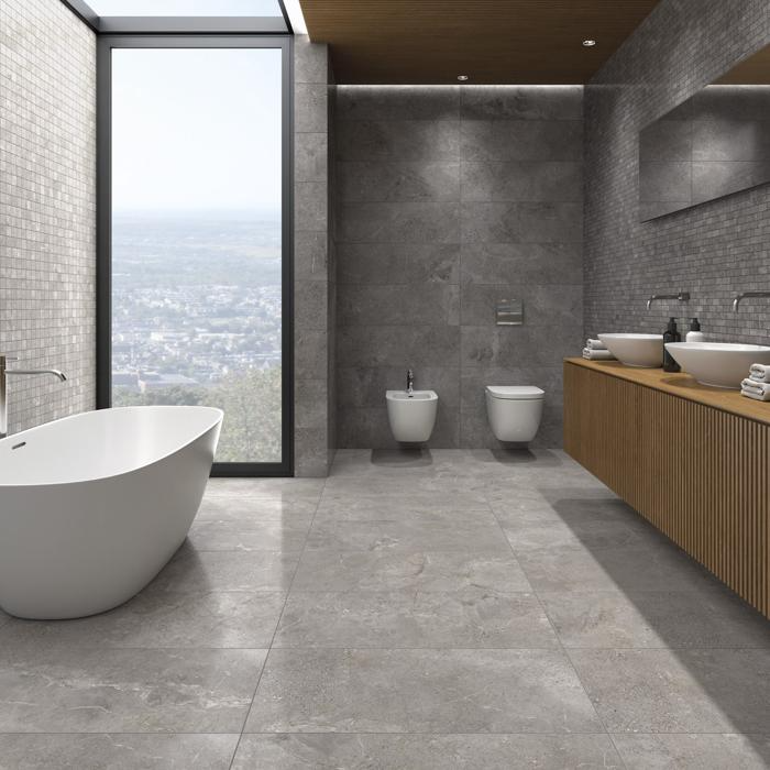 Spacious bathroom with grey stone tiles and city view