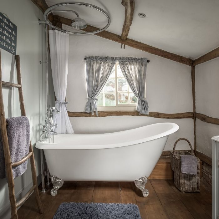 Cottage-style bathroom with clawfoot tub and wooden beams