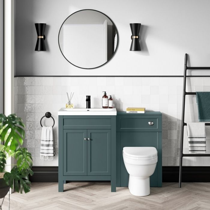 Green vanity unit with white tiled walls and round mirror