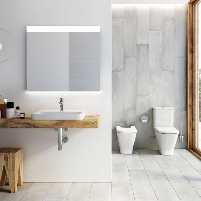 White sink with wooden countertop and grey tiles