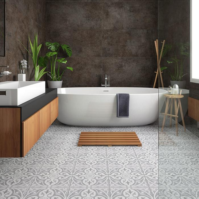 White bathtub and grey patterned tiles underneath