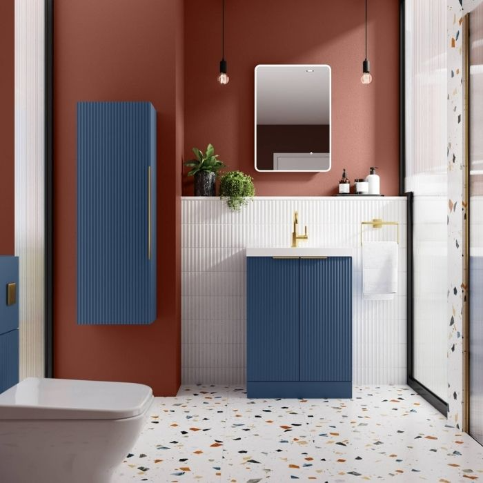 Blue vanity with terrazzo flooring and red walls