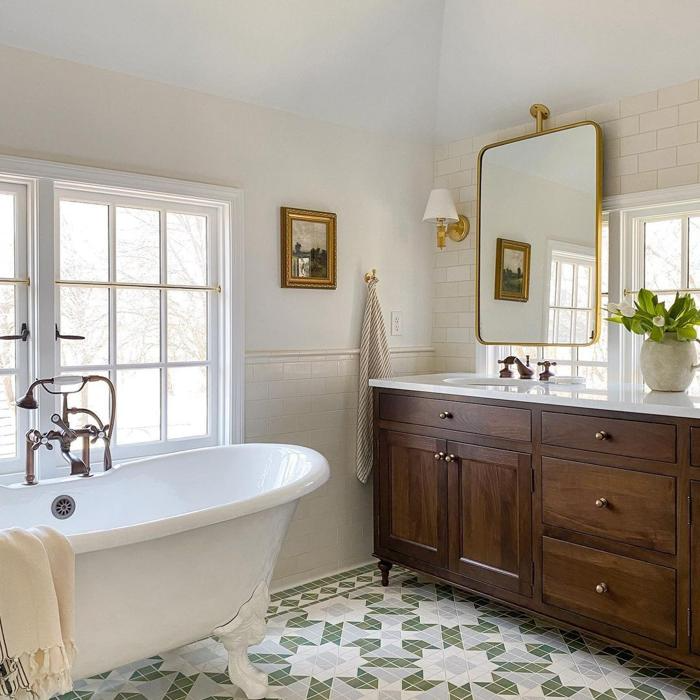 Clawfoot tub and intricate floor tiles in bathroom