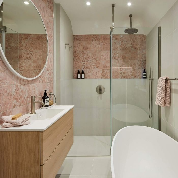 Soft pink tiles in modern family bathroom with glass shower