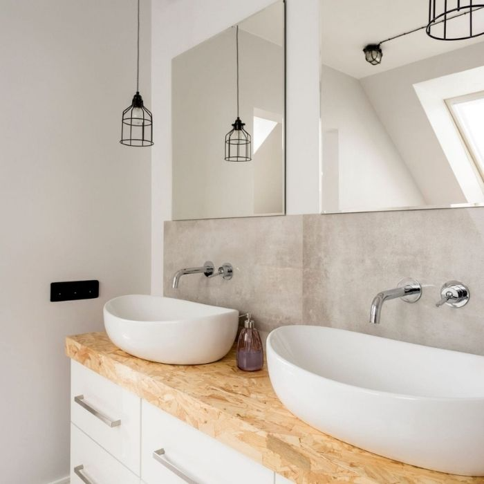 White oval sinks on a wooden countertop with neutral walls